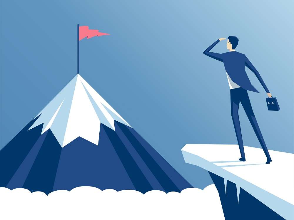 A man (investor) standing on a cliff, and staring at his goal - a mountain peak (his goal)